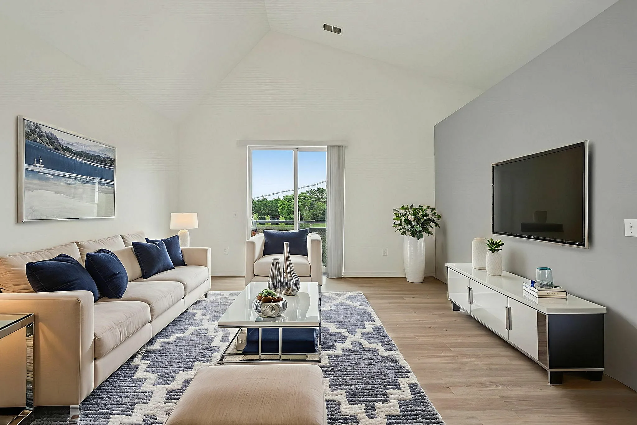 Bright and modern living room featuring vaulted ceilings and plank flooring!