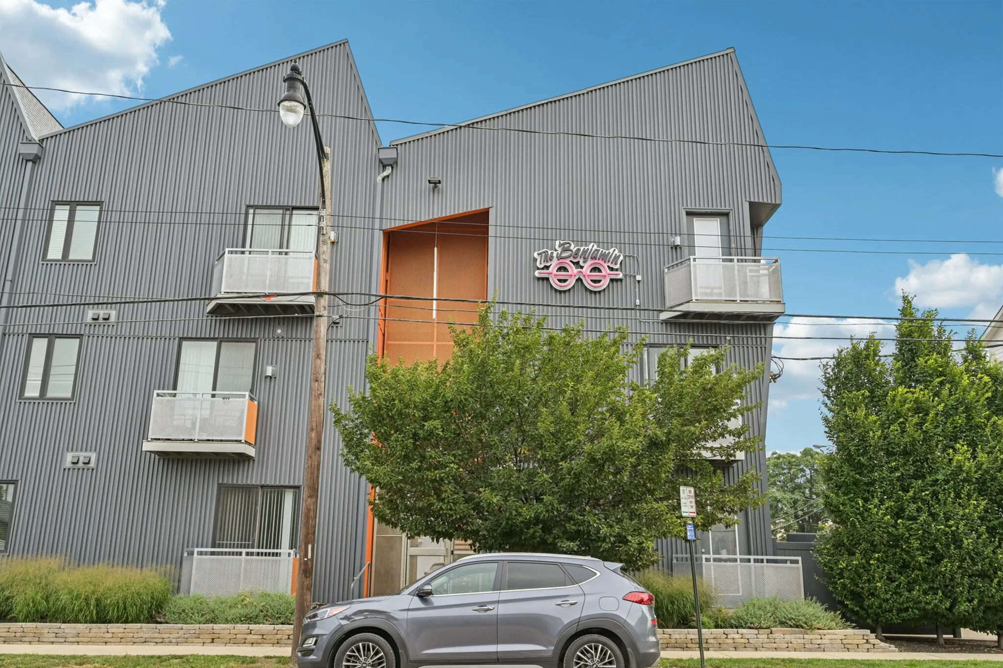 Contemporary apartment building with unique architectural design, featuring metal cladding and private balconies, offering a modern living experience.