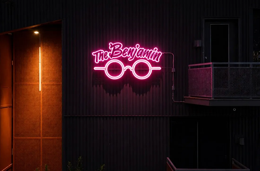 Chic urban aesthetic with neon sign reading 'The Benjamin' highlighting modern design.