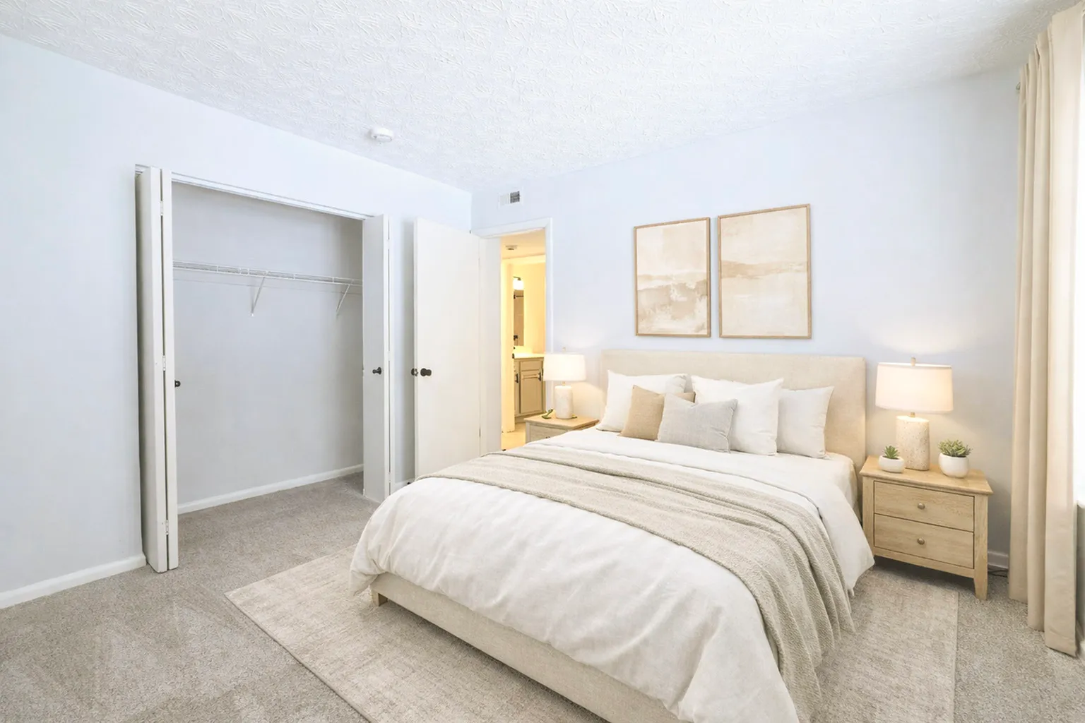 Bright and cozy bedroom with elegant decor, featuring a plush bed, soft lighting, and ample closet space.