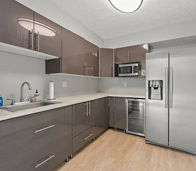 Modern apartment kitchen featuring sleek high-gloss cabinets, stainless steel appliances, and a spacious countertop.
