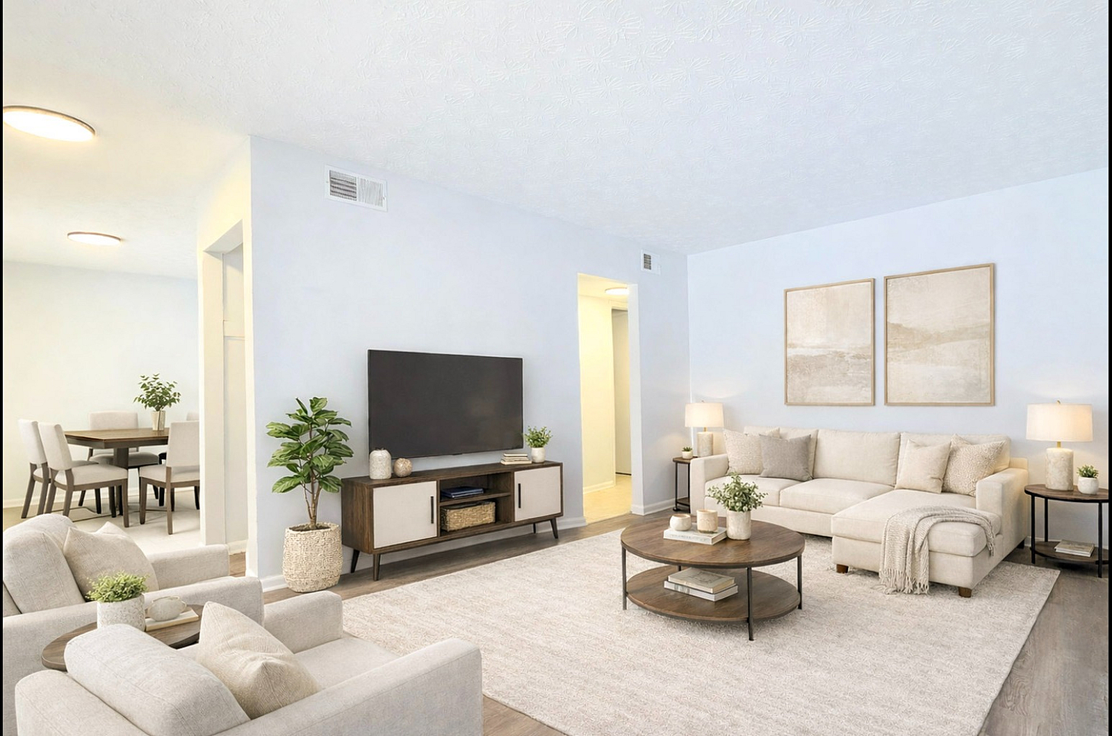 Bright and airy living room with modern furnishings, featuring a cozy sectional sofa, stylish decor, and a sleek entertainment unit, seamlessly connected to an elegant dining area.