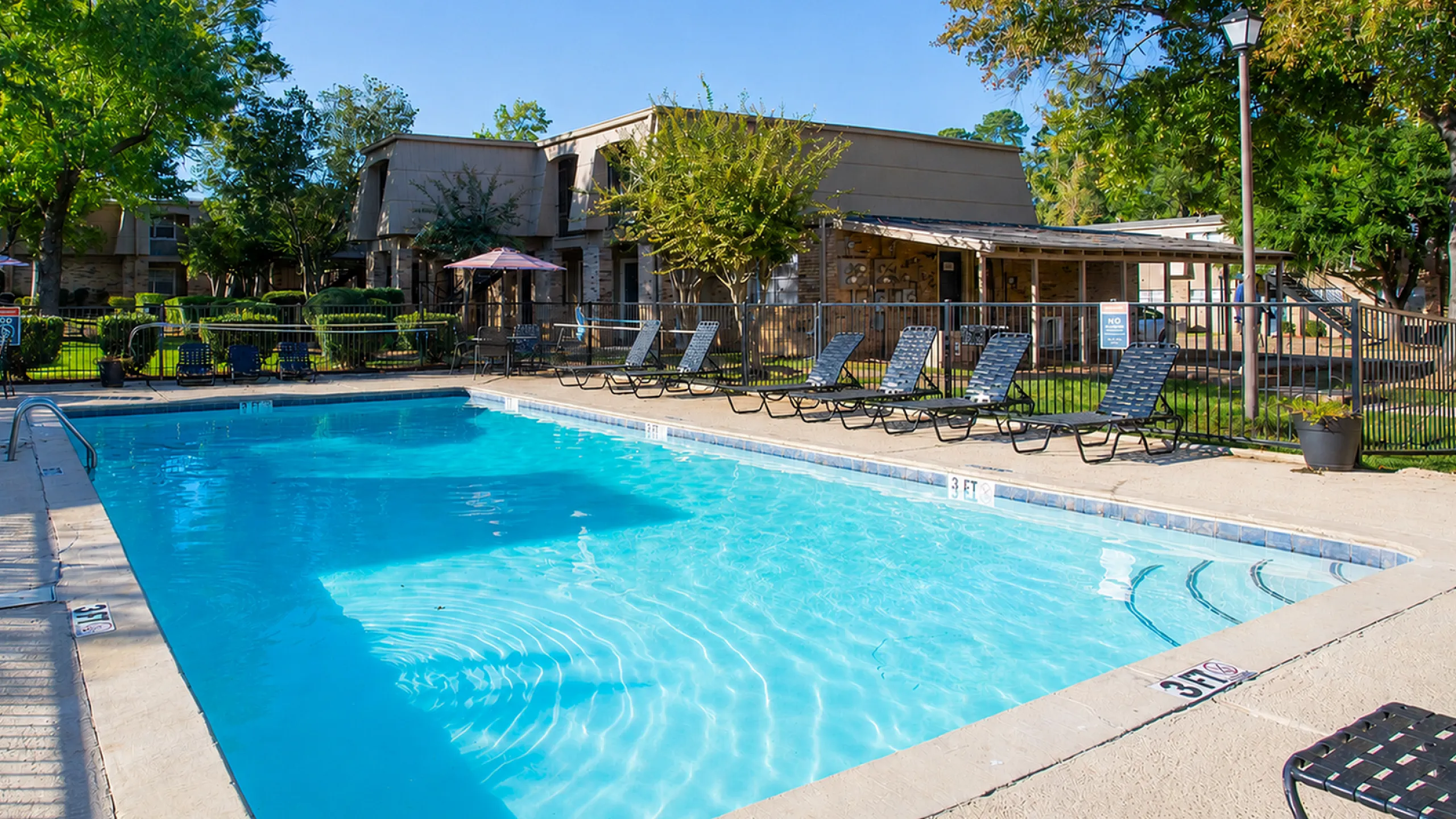 Inviting outdoor pool area with sun loungers and vibrant landscaping, perfect for relaxation and leisure.