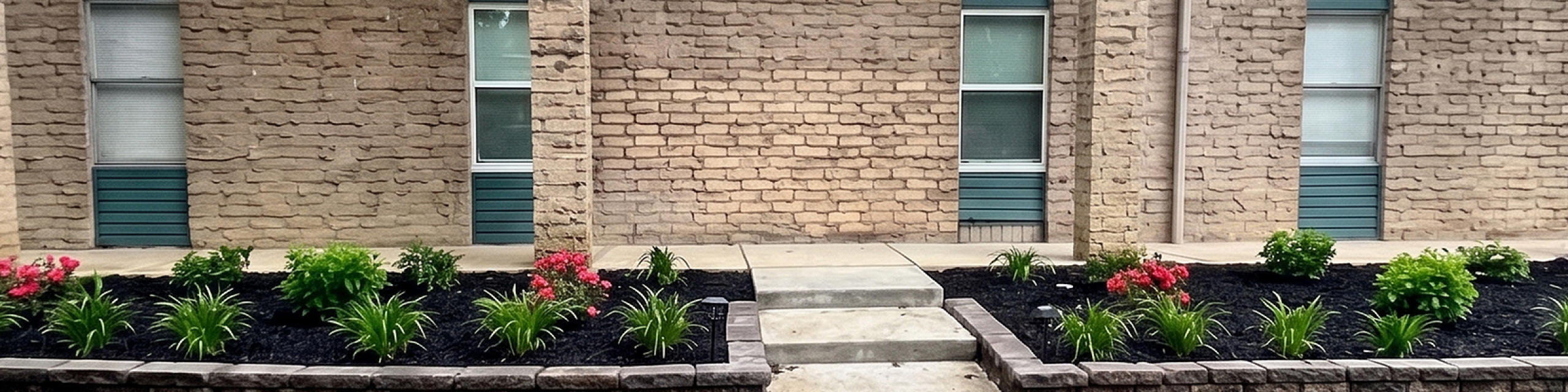 Charming brick apartment exterior with modern vertical windows, surrounded by lush landscaped gardens.