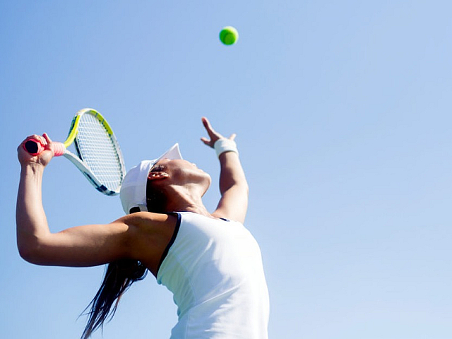 Woman Serving tennis ball