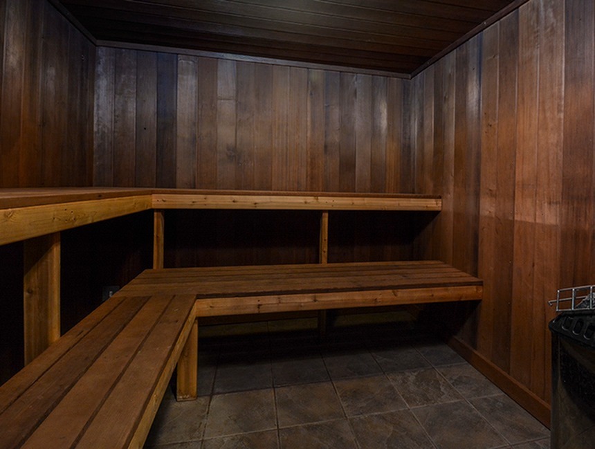 Sauna with wood walls, 2 levels of seats and stone floor.