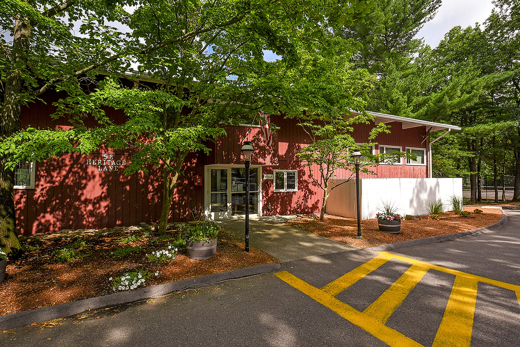 Charming red building surrounded by lush greenery, featuring a welcoming entrance at 58 Heritage Lane.