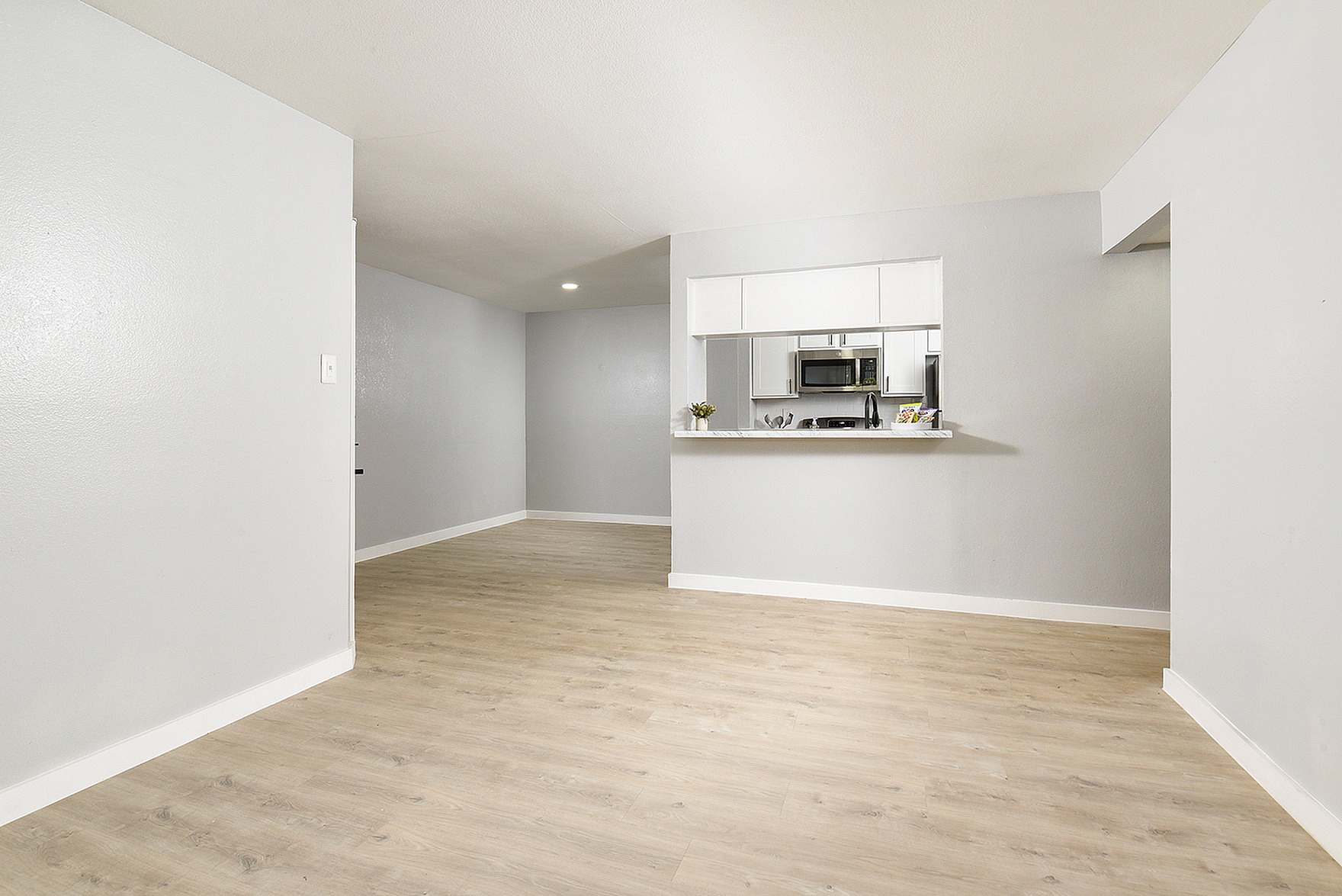 Contemporary open-plan space with elegant hardwood floors and a modern kitchen, ideal for stylish living.