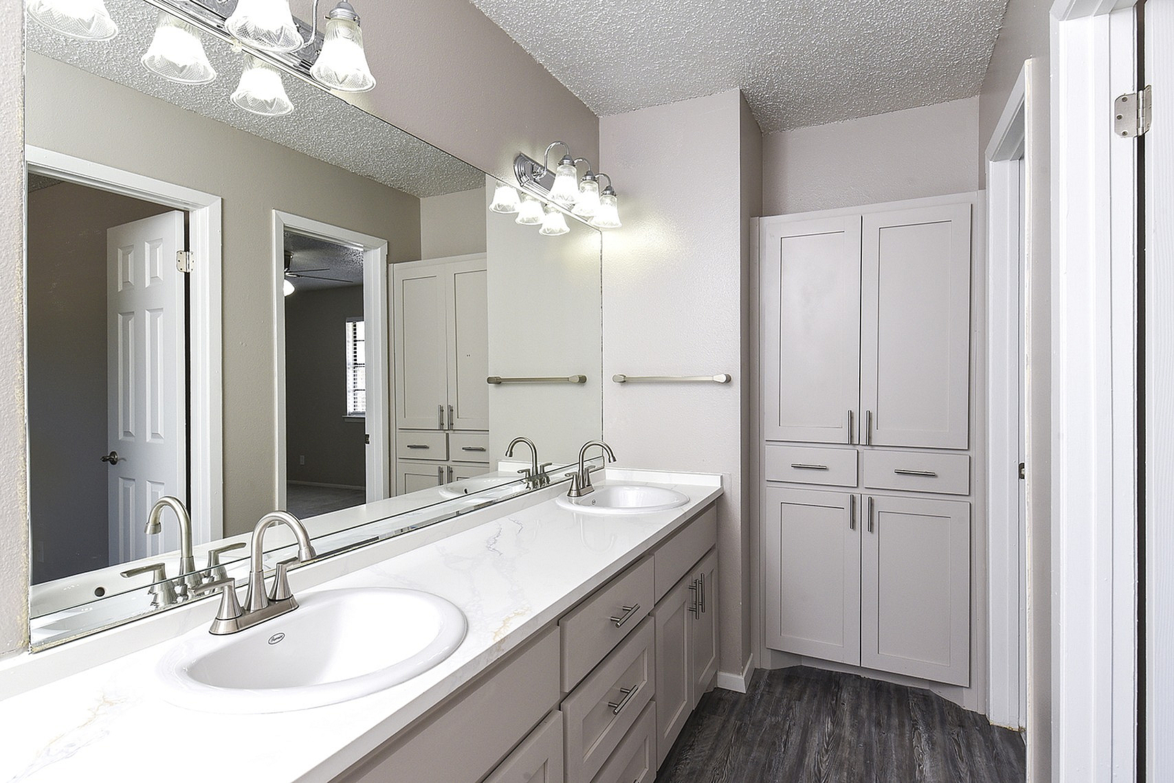 Elegant modern bathroom featuring dual sinks, sleek cabinetry, and contemporary lighting.