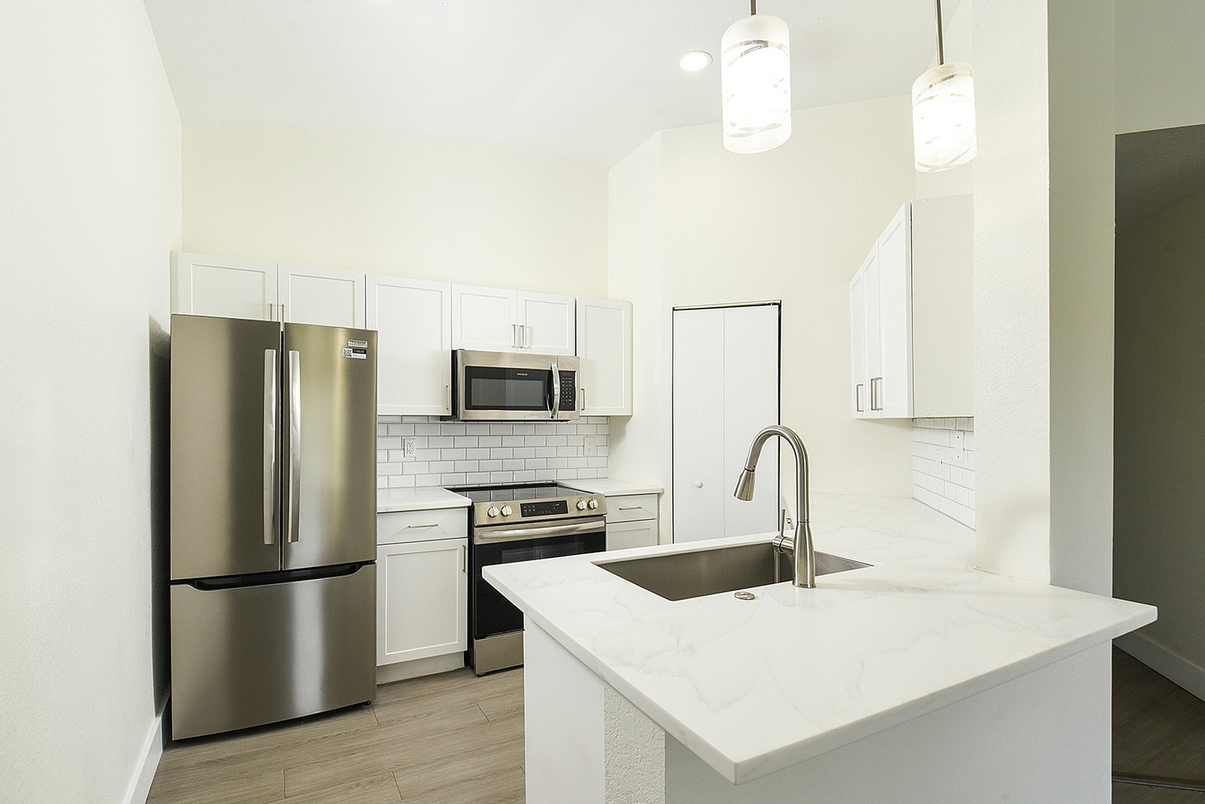 Modern kitchen with sleek stainless steel appliances, elegant white cabinets, and a stylish marble countertop.