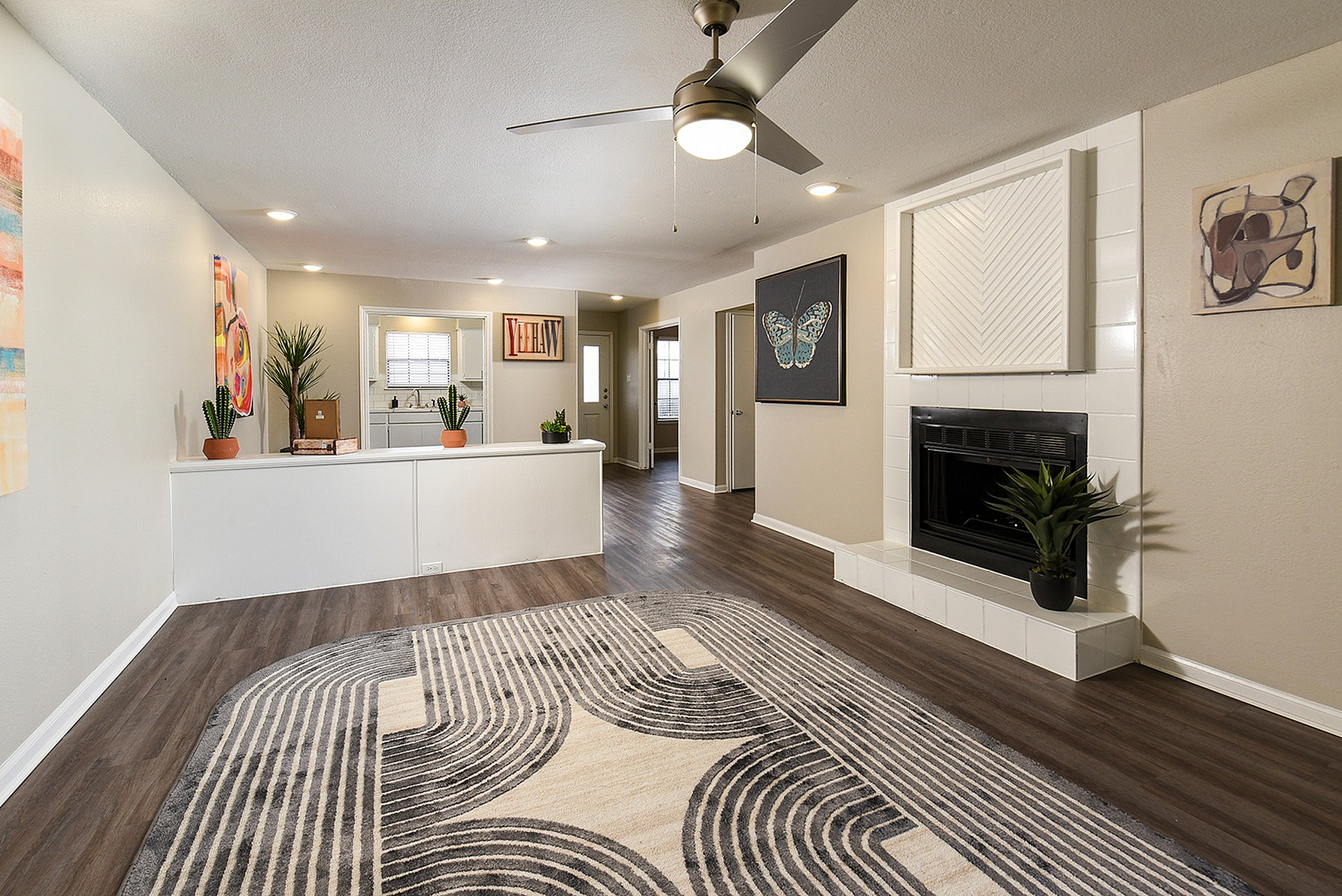 Contemporary living room with sleek flooring, cozy fireplace, and stylish decor in a well-lit open space.