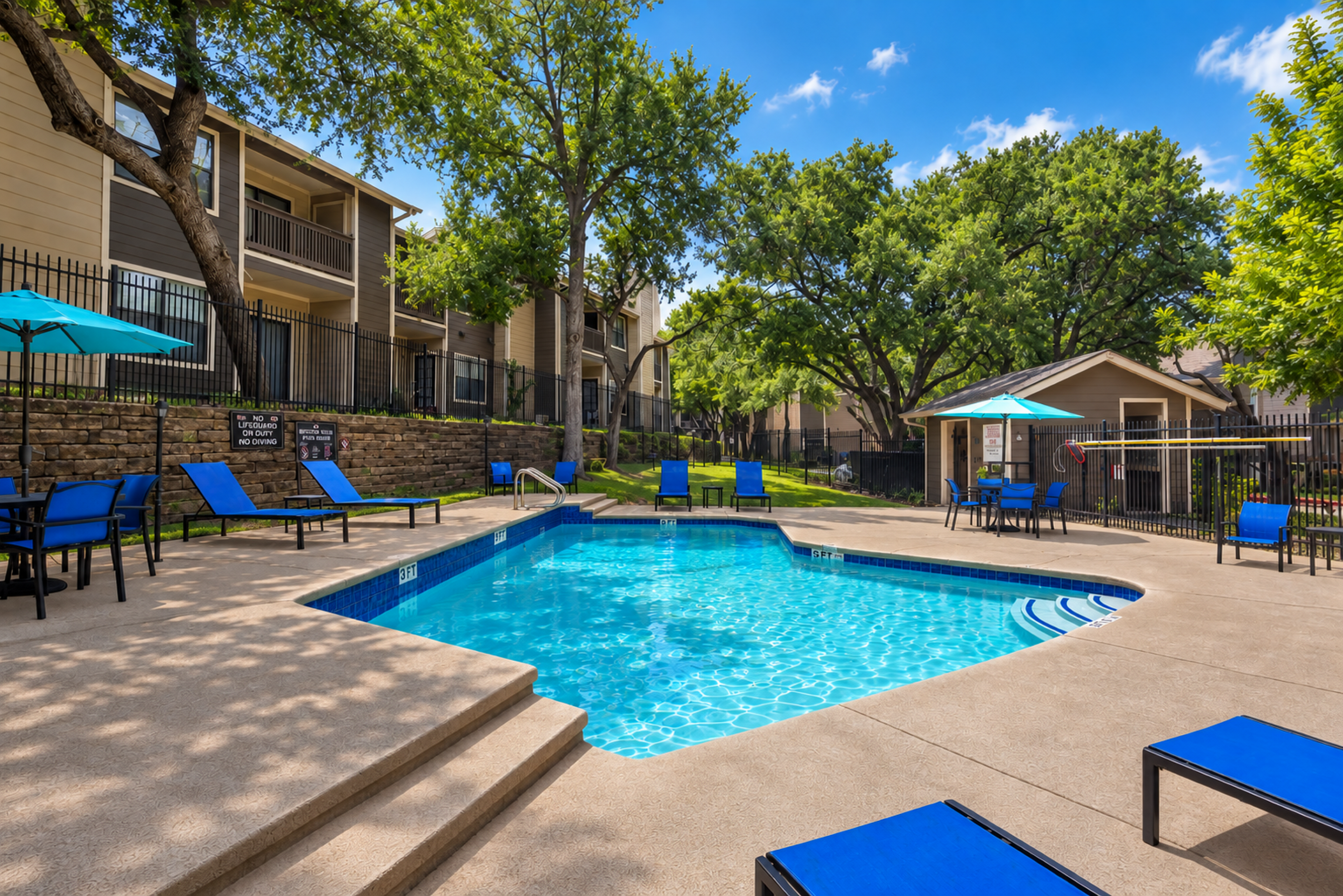 Inviting outdoor pool area with vibrant blue lounge chairs and lush green surroundings, perfect for relaxation and leisure.