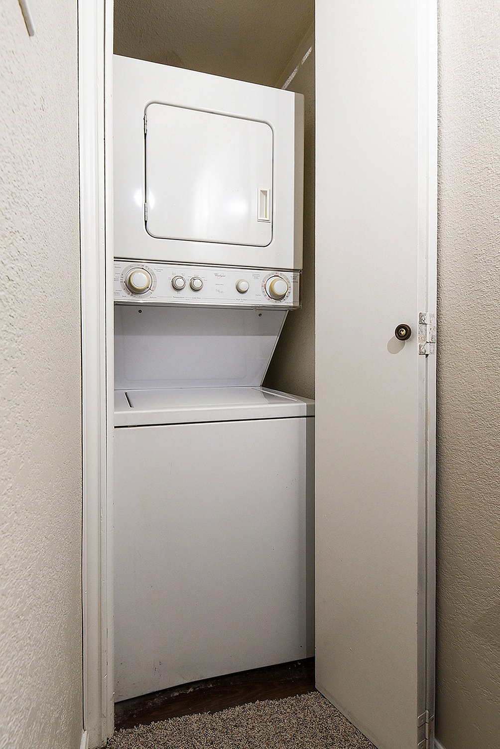 Compact laundry closet featuring an efficient stacked washer and dryer.