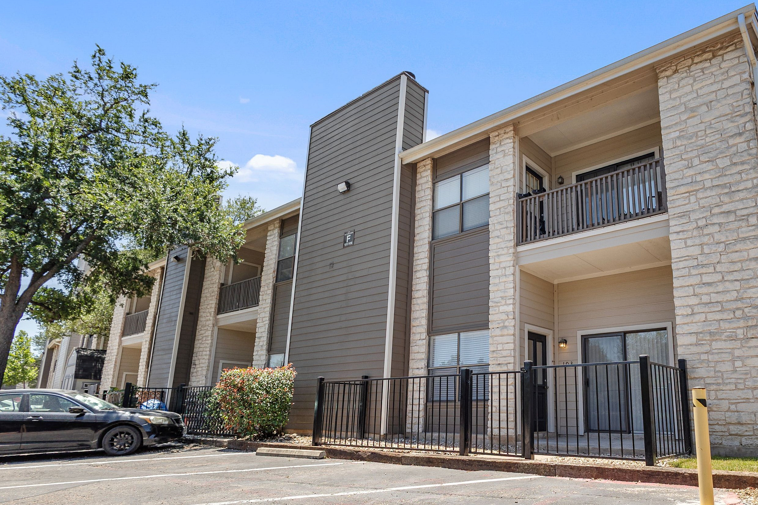 Charming apartment exterior with a modern facade, private balcony, and lush surroundings.