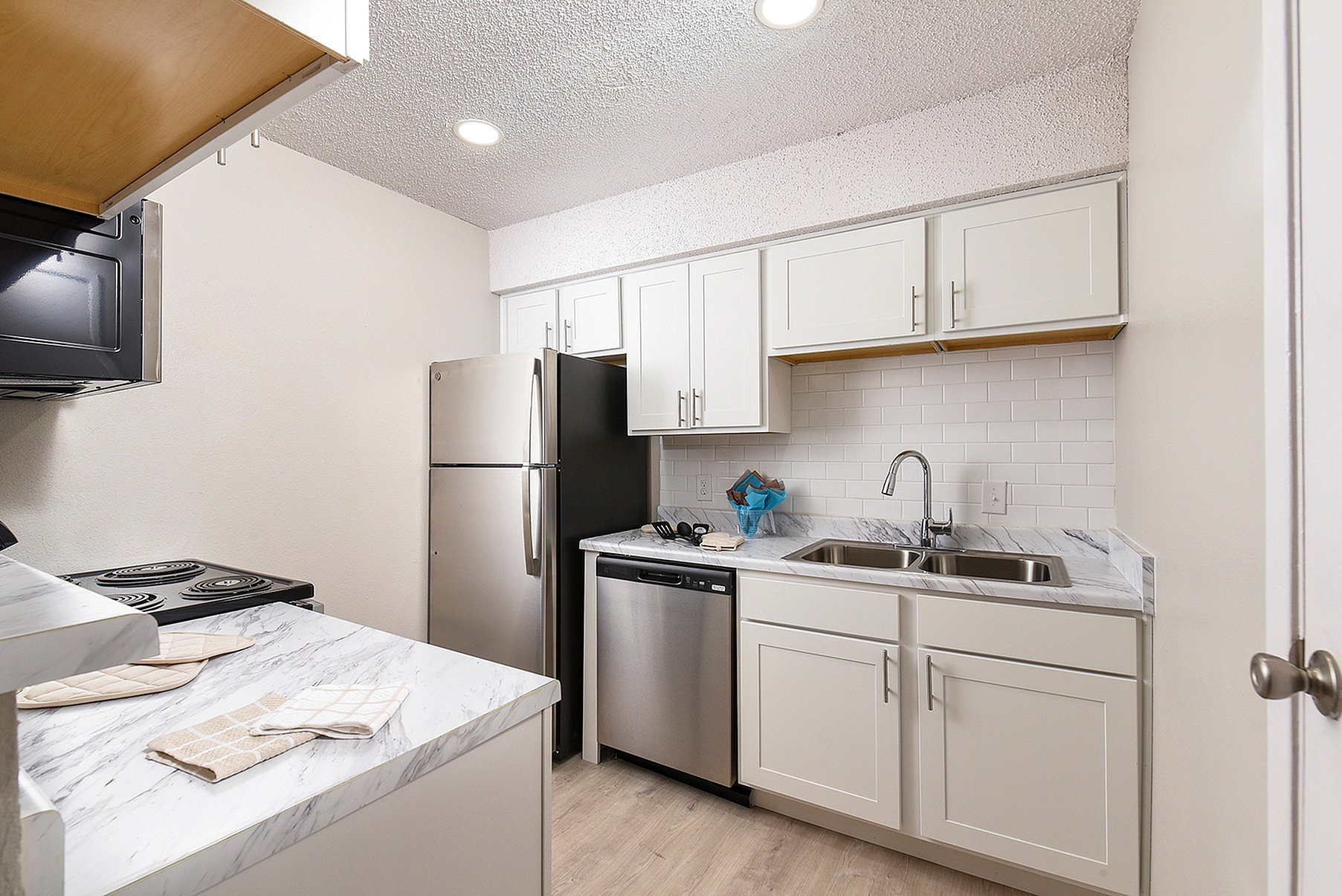 Modern kitchen with sleek white cabinets, stainless steel appliances, and elegant marble countertops.