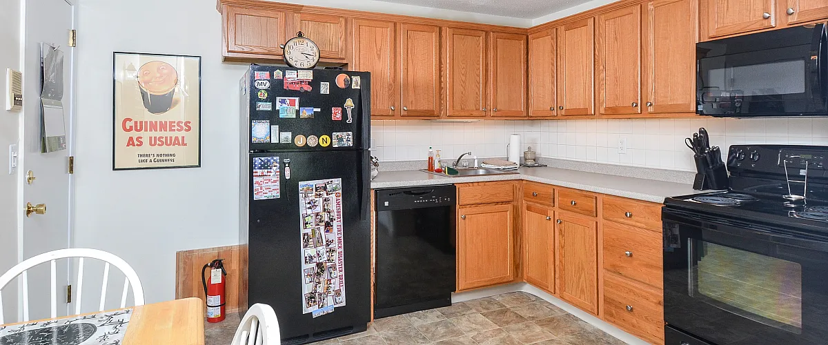 Kitchen | Oak cabinets and black appliances.