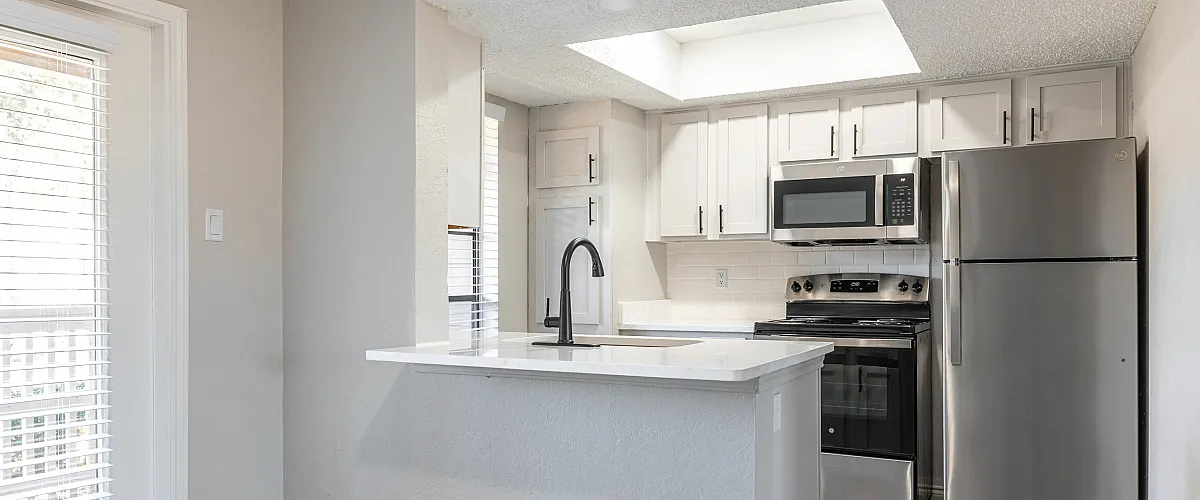 Sleek kitchen with stainless steel appliances, modern cabinetry, and a bright breakfast bar area.