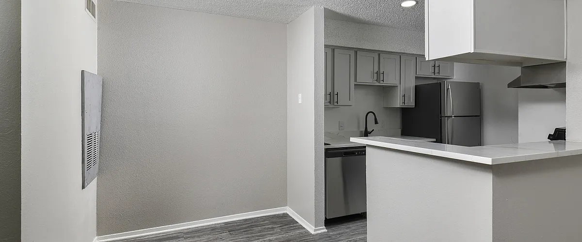 Modern apartment kitchen with sleek cabinetry, stainless steel appliances, and a quartz countertop.