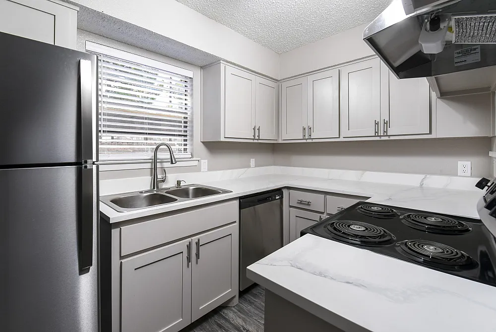 Modern kitchen with sleek stainless steel appliances, white cabinetry, and elegant countertops.