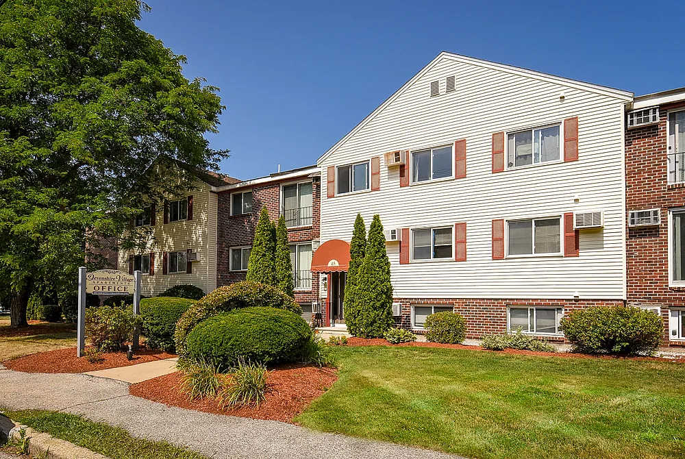 Charming apartment building surrounded by lush greenery and featuring a welcoming entrance.