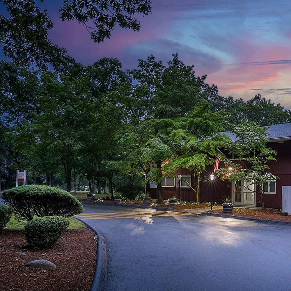 Charming, rustic exterior of a residential building surrounded by lush greenery at sunset, highlighting a tranquil and inviting atmosphere.