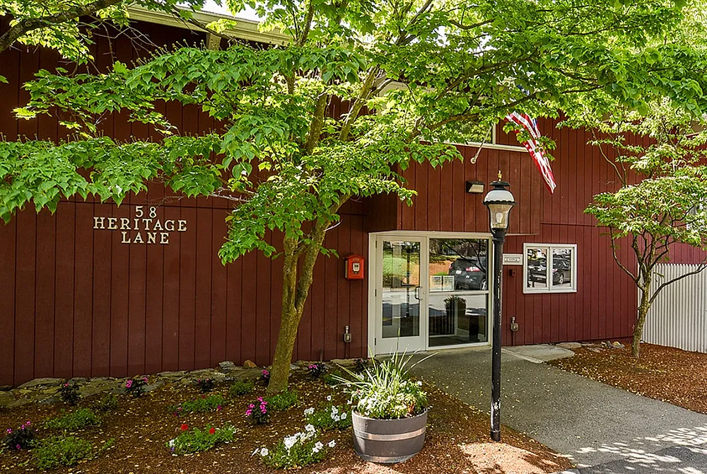 Charming apartment exterior at 58 Heritage Lane with vibrant landscaping and inviting entrance, surrounded by lush greenery.