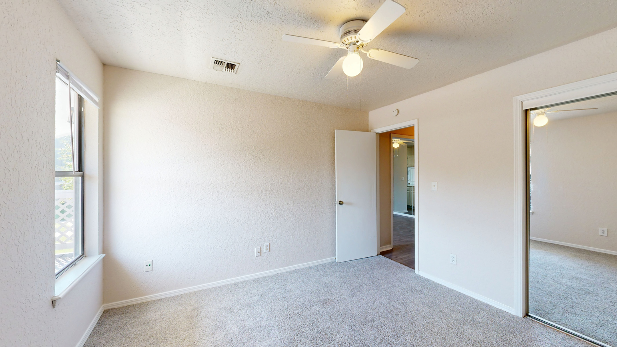 Enjoy comfort and convenience in this airy bedroom with ample storage.