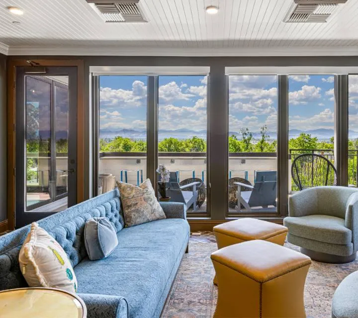 Bright community room with plush seating and a stunning panoramic view of the outdoors.