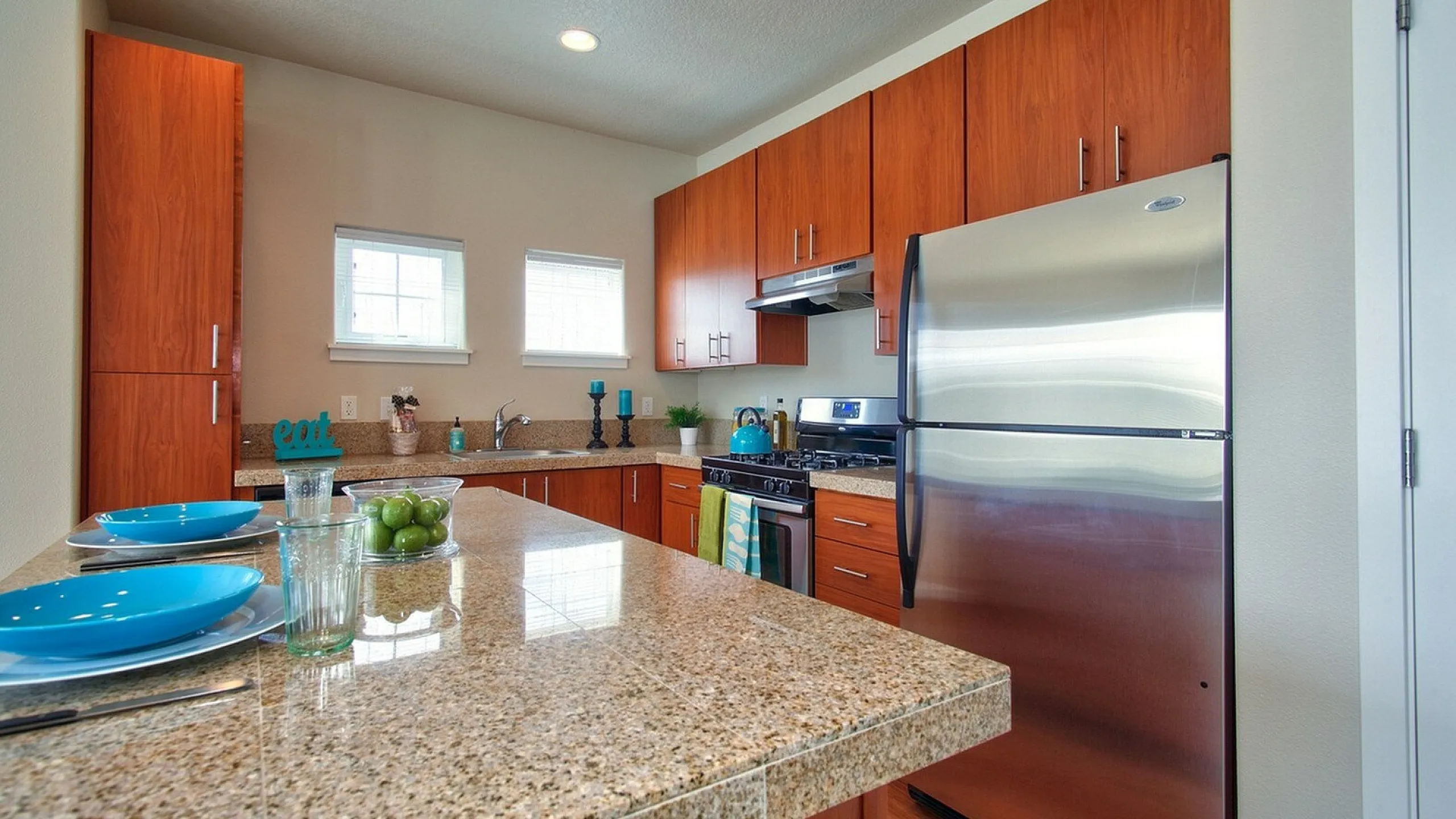 Sleek kitchen with granite countertops, stainless steel appliances, and warm wooden cabinetry.