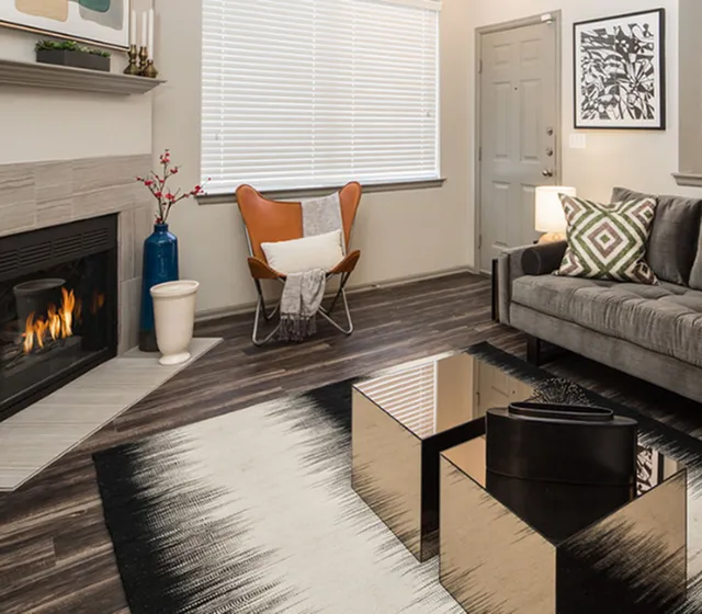 Inviting living room with elegant fireplace, chic modern furniture, and stylish decor in a cozy apartment setting.