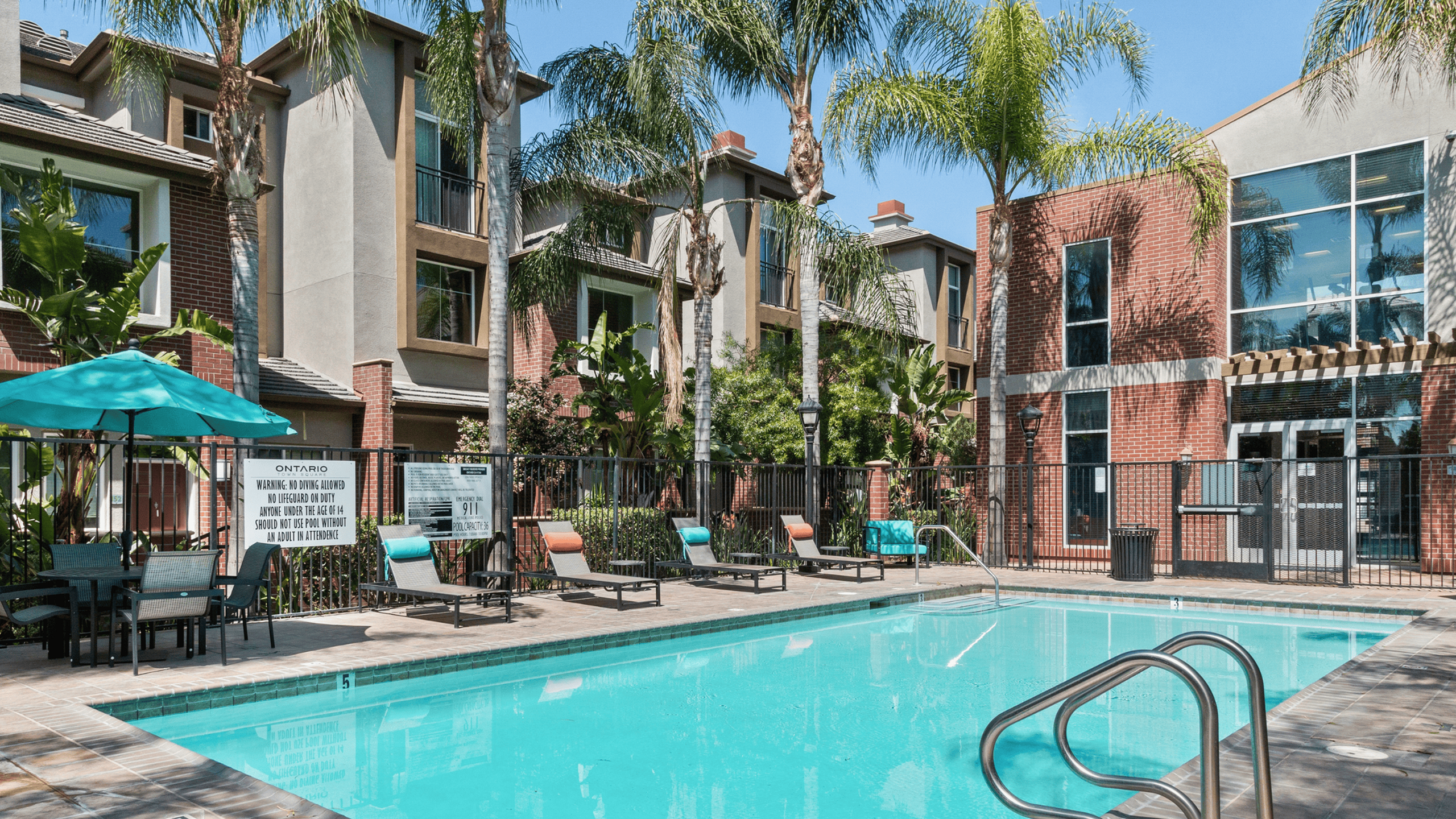 Luxurious apartment complex with a refreshing swimming pool, surrounded by lush greenery and modern architecture.