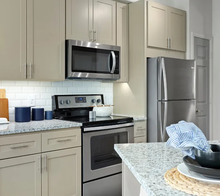 Modern kitchen with sleek stainless steel appliances, elegant granite countertops, and stylish cabinetry.