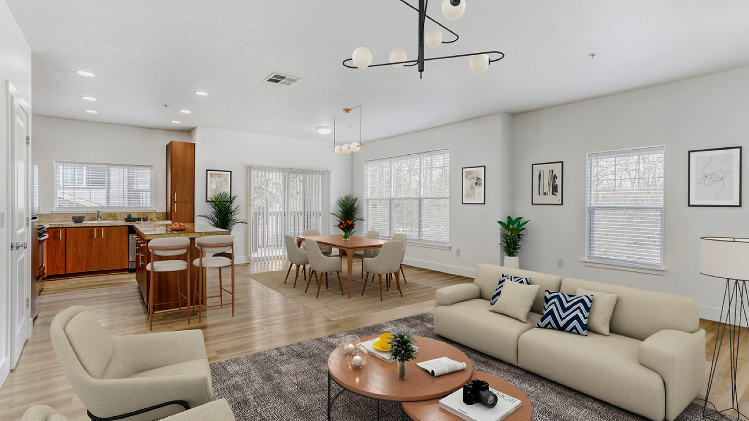 Bright and modern open-concept living area showcasing a sleek kitchen with granite countertops, cozy dining space, and elegant lounging area with stylish decor.
