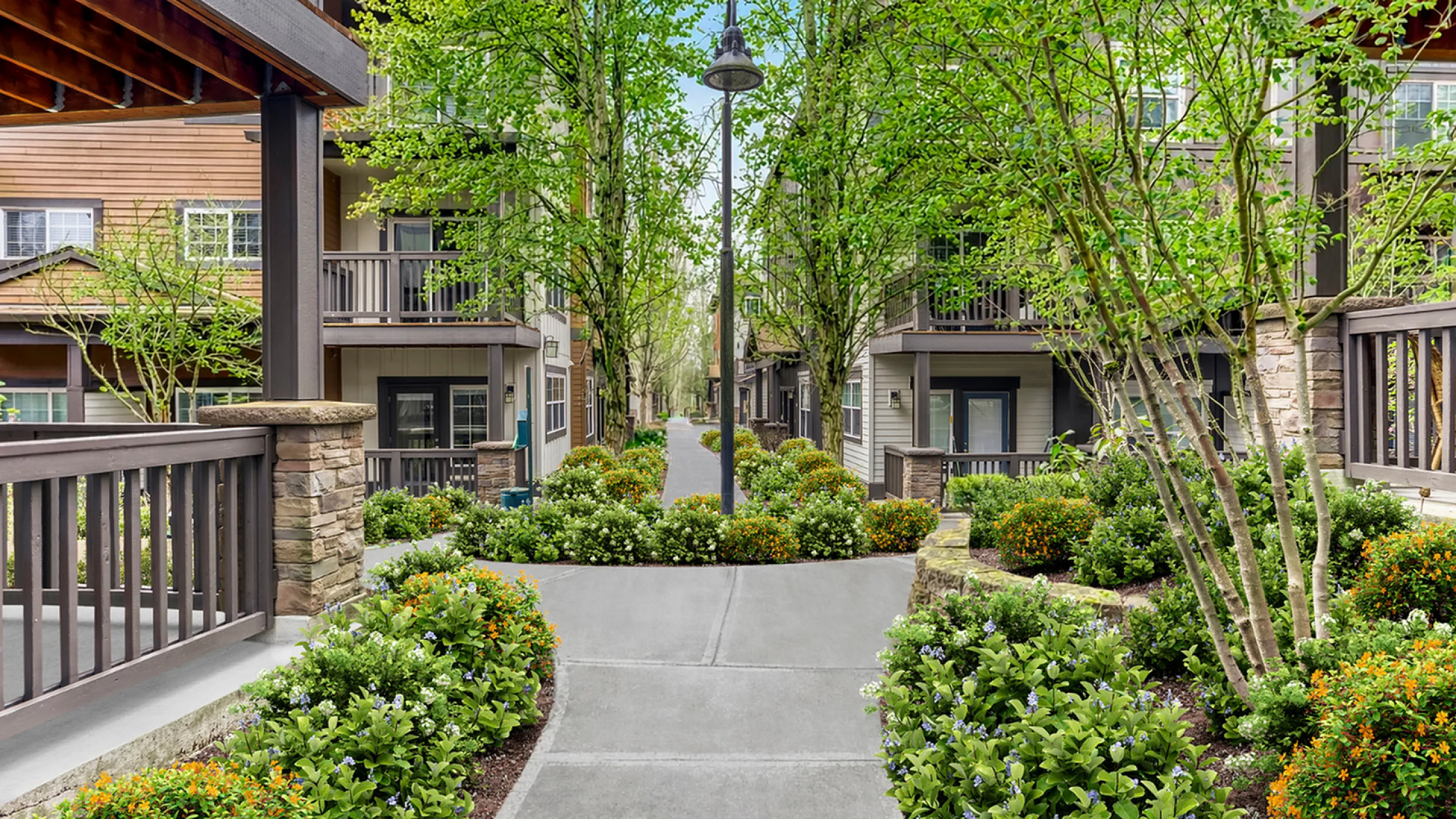 Charming apartment complex with lush landscaped gardens, vibrant flowers, and elegant balconies, offering a tranquil urban oasis.