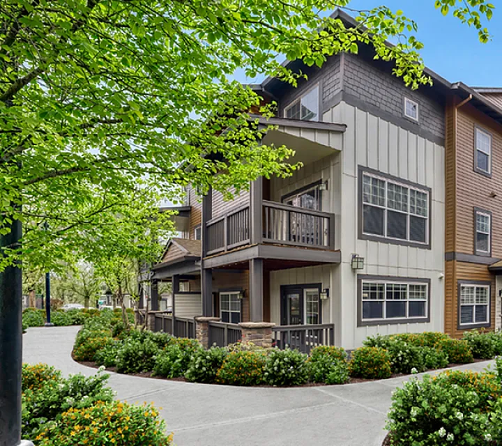 Charming multi-story apartment building with inviting balconies and lush landscaped surroundings, offering serene living in a vibrant neighborhood.