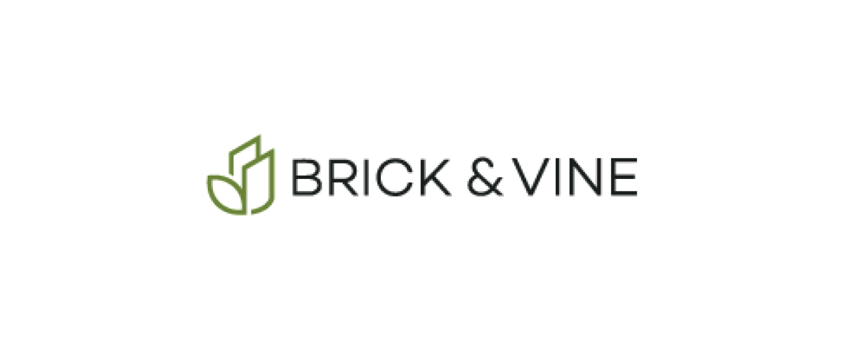 Charming apartment complex with modern design, surrounded by lush greenery, offering comfortable living spaces at Brick & Vine.