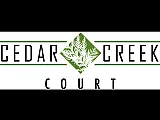 Distinctive logo of Cedar Creek Court featuring elegant green and white design elements.