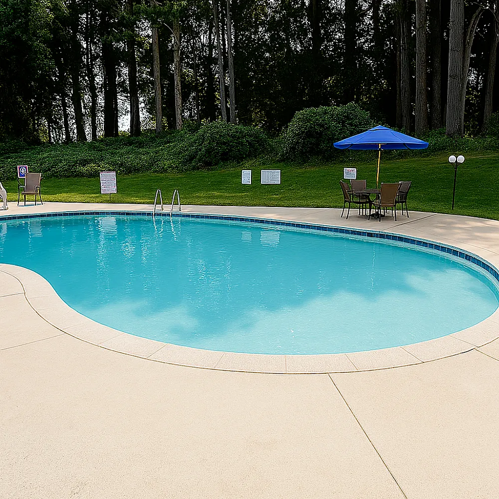 Inviting outdoor pool with crystal-clear water, surrounded by lush greenery and comfortable seating under a vibrant blue umbrella.