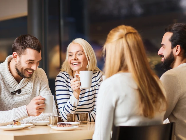 Group of friends enjoying coffee and conversation together at a café.