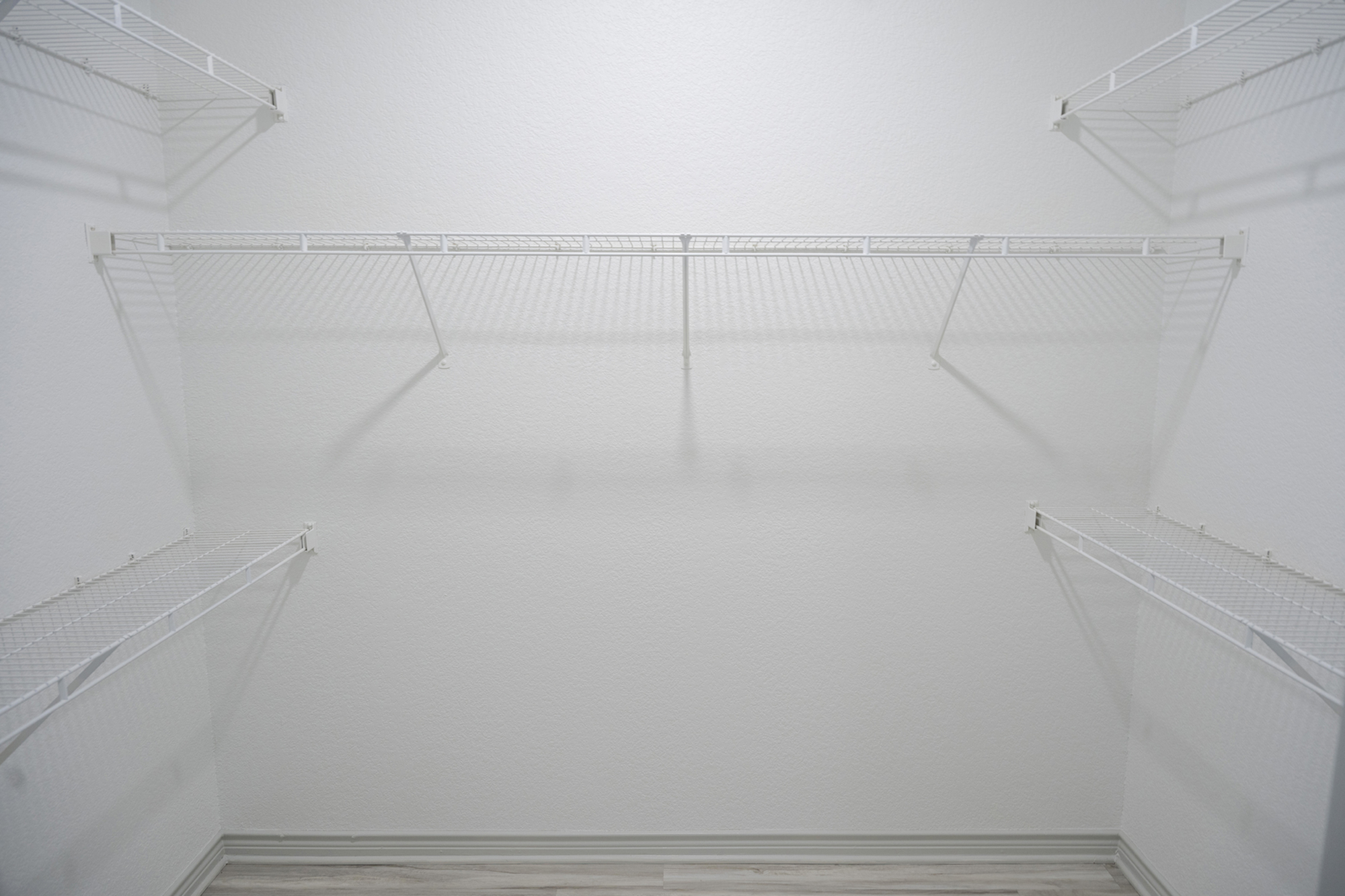Spacious walk-in closet with sleek wire shelving, ideal for organizing clothing and accessories.