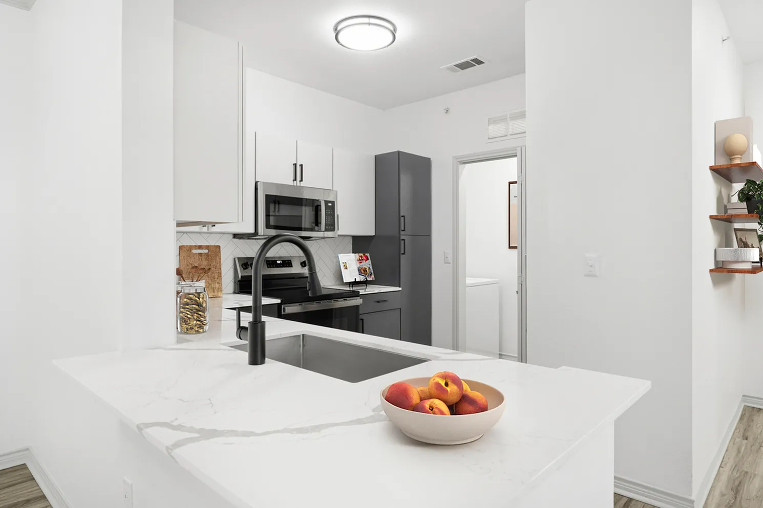 Modern kitchen with sleek white cabinetry, stainless steel appliances, and elegant marble countertops, creating a sophisticated culinary space.
