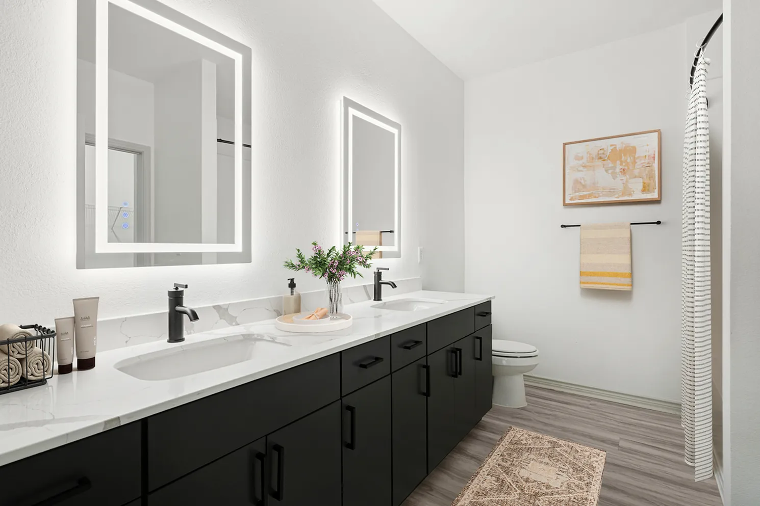 Modern bathroom featuring sleek black cabinets, double sinks with elegant fixtures, illuminated mirrors, and stylish decor.