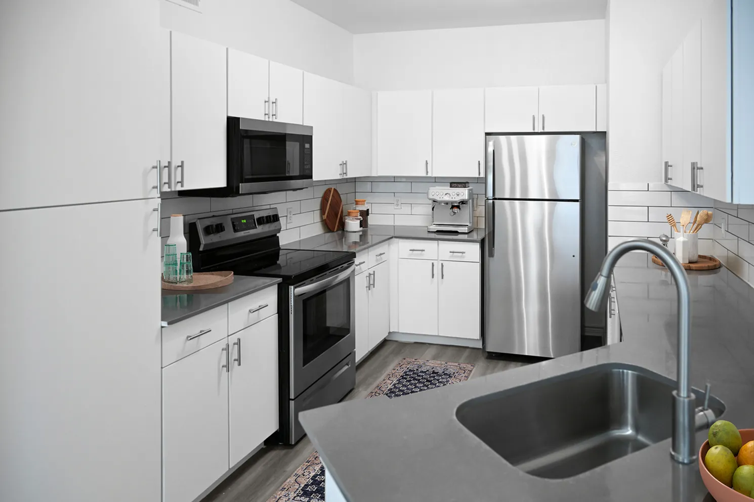 Modern kitchen with sleek stainless steel appliances, white cabinetry, and stylish countertops.