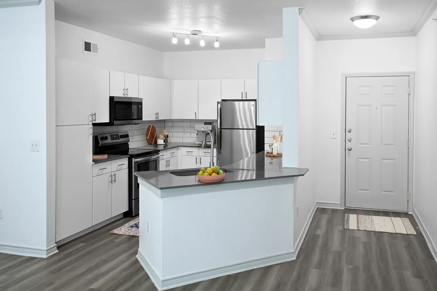 Modern kitchen with sleek white cabinetry, stainless steel appliances, and elegant countertops, perfect for gourmet cooking.