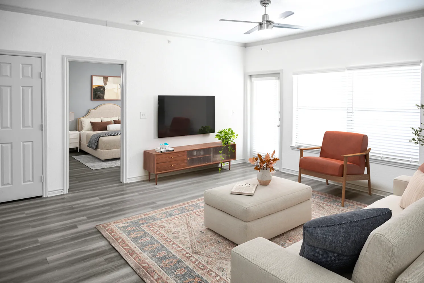 Bright and modern living room featuring chic furniture, stylish rug, and a large window allowing abundant natural light.