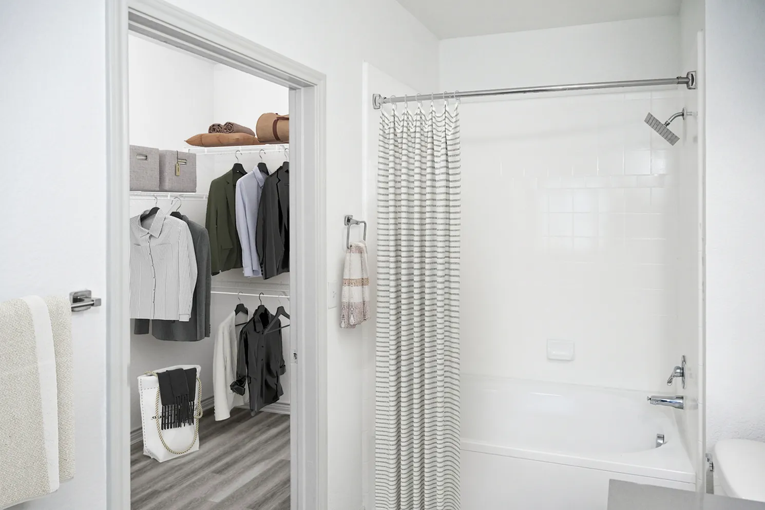 Chic apartment bathroom with elegant white tiles and a spacious walk-in closet, featuring contemporary shelving and stylish clothing displays.