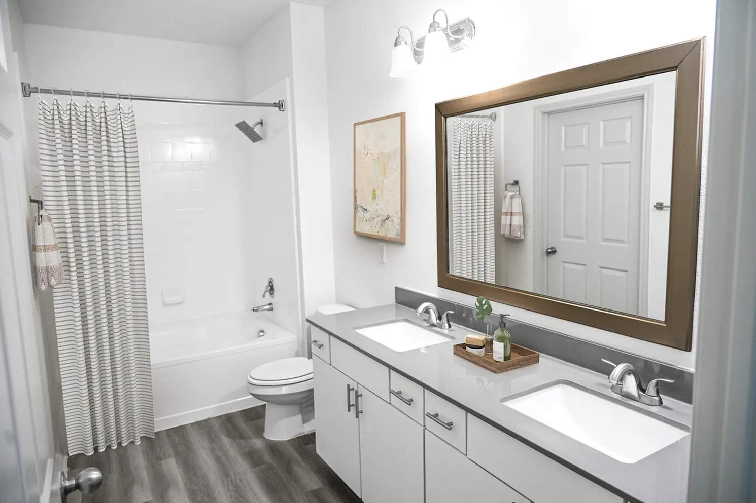 Elegant bathroom featuring dual sinks, modern fixtures, and chic decor with a spacious tub.