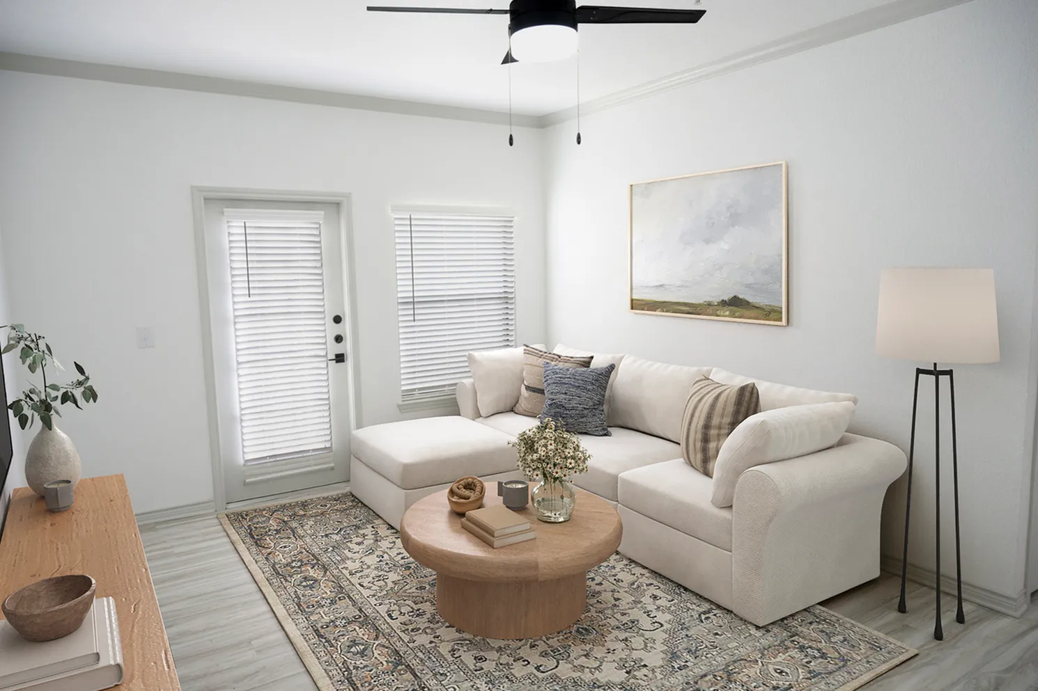 Cozy living room with a stylish beige sectional sofa, chic round wooden coffee table, and elegant decor, featuring a serene painting and contemporary floor lamp.