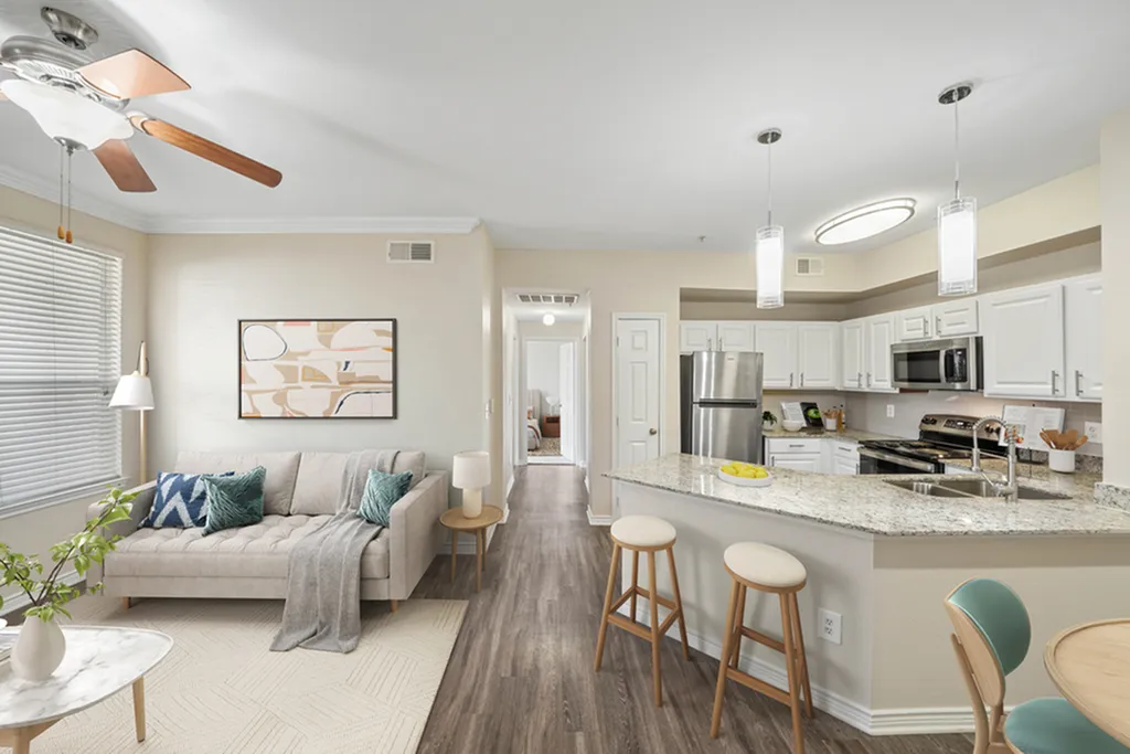 Charming open-concept living room and kitchen with elegant decor, natural light, and modern appliances.