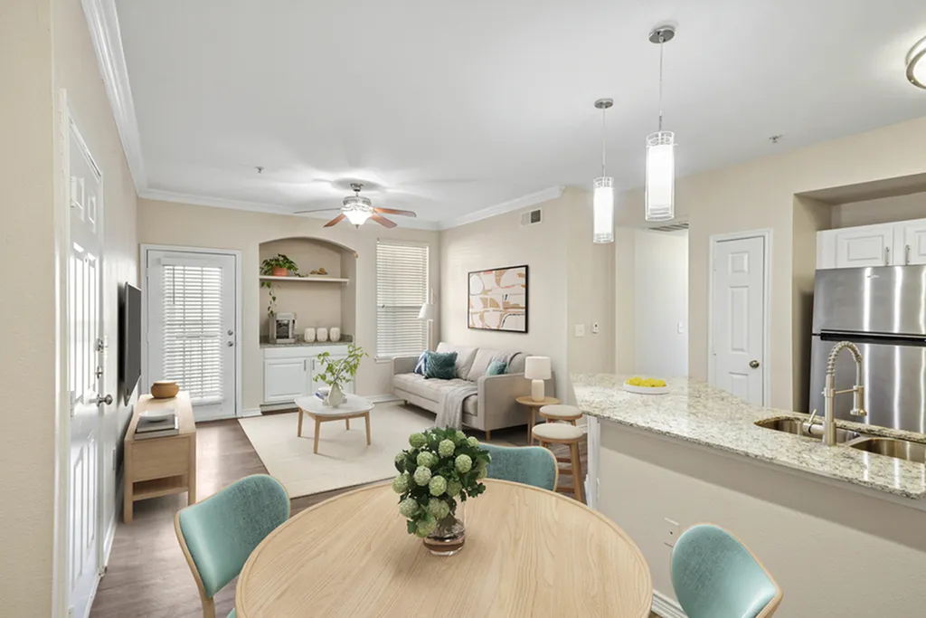 Chic open-concept living space featuring a cozy sitting area, modern kitchen with granite countertops, and stylish dining set, perfect for entertaining.